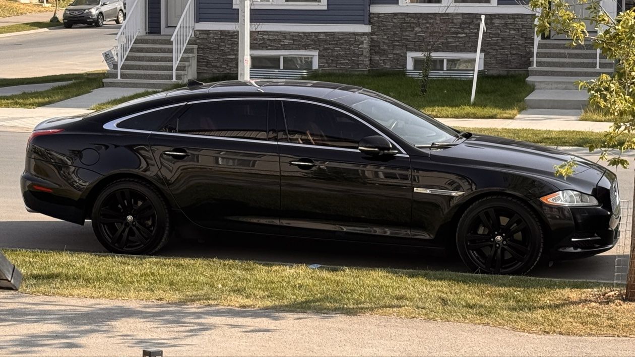 A black Jaguar sedan parked on a city street